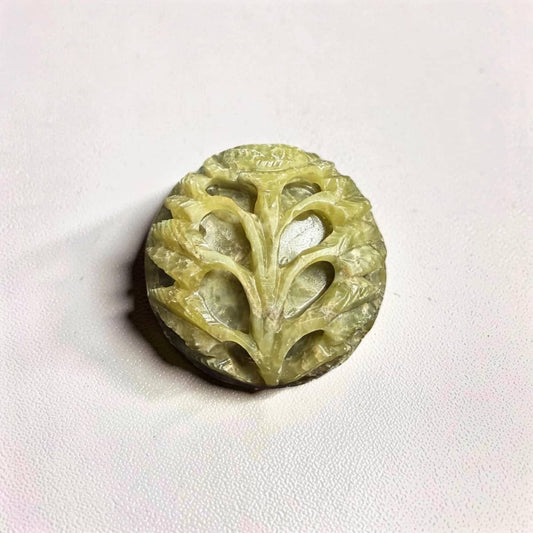 Decorative stone with intricate carvings on a white background