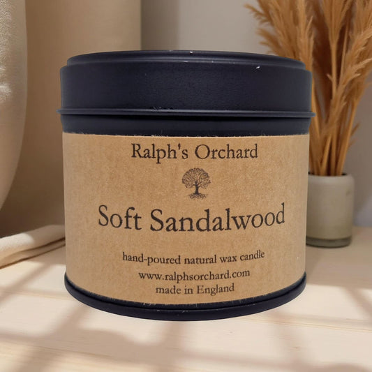 Candle labeled 'Ralph's Orchard Soft Sandalwood' on a neutral background