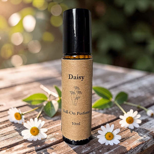 Roll-on perfume bottle labeled 'Daisy' on a wooden surface with daisies.