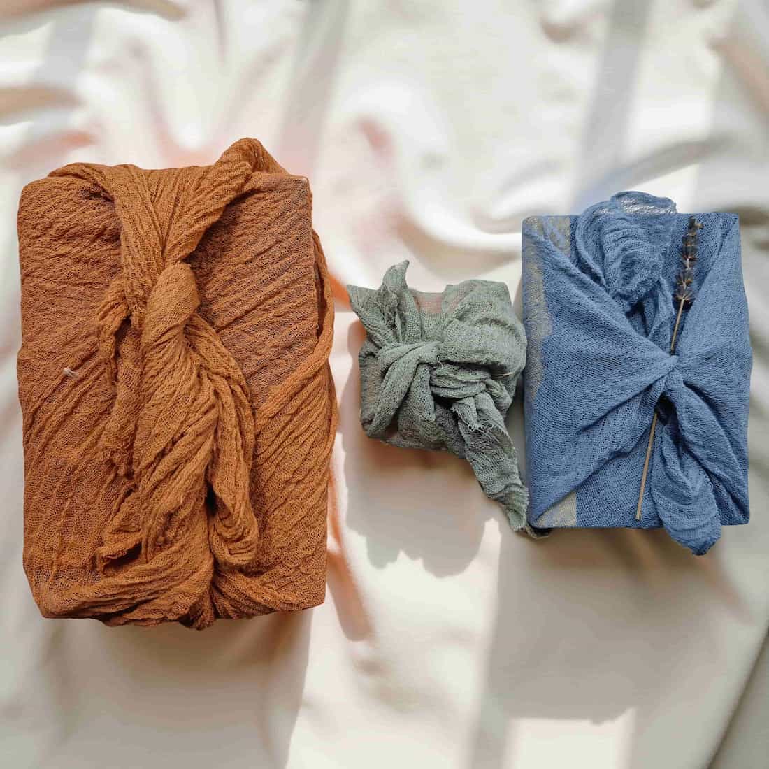 Three gifts in brown, gray, and blue on a light background