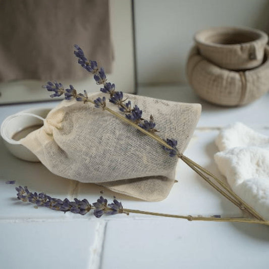 Lavender sachet with lavender flowers on a white surface