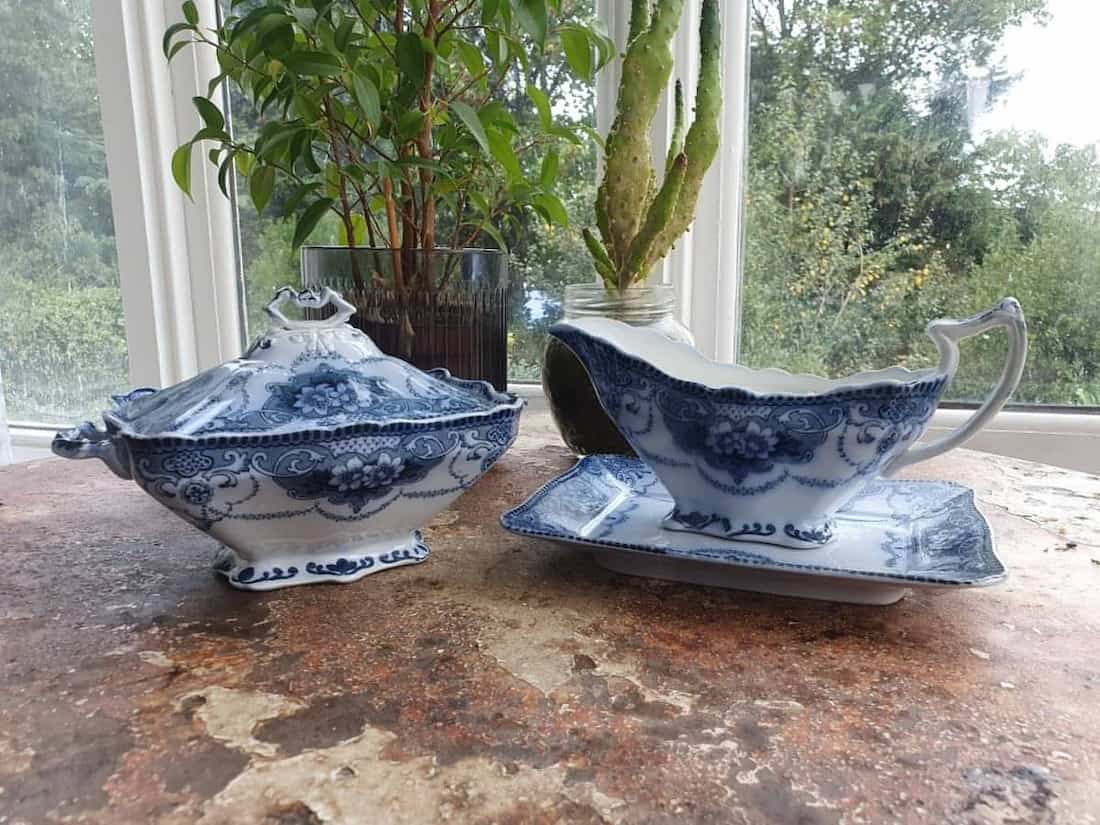 Blue and white ceramic serving dishes on a wooden surface with a window in the background.