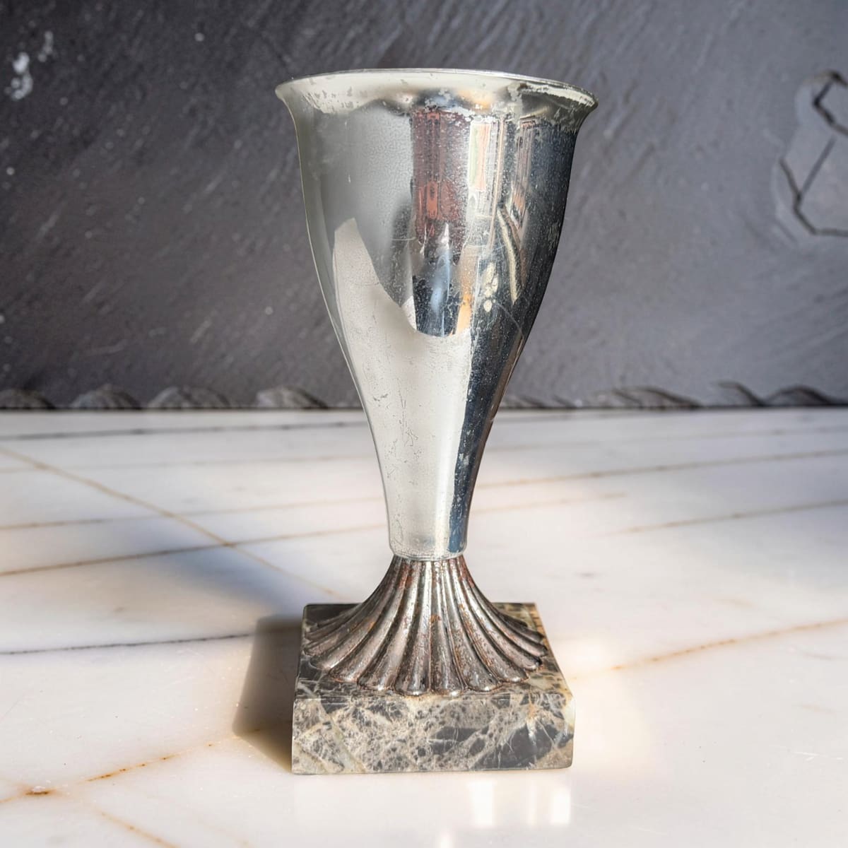 Silver trophy on a marble surface with a dark background