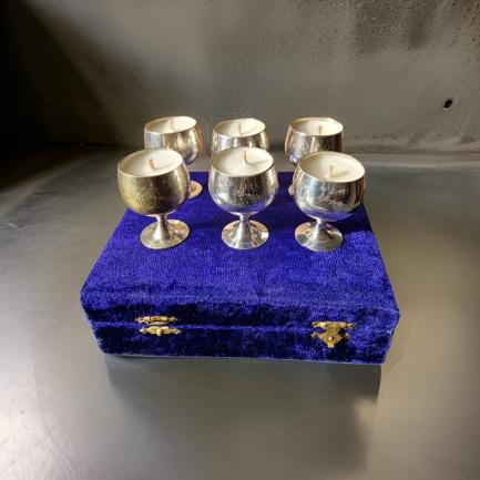 Silver candle holders on a blue velvet box on a textured surface