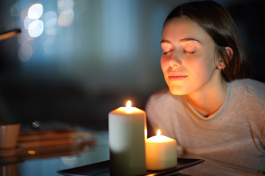 woman sniffing lit candle
