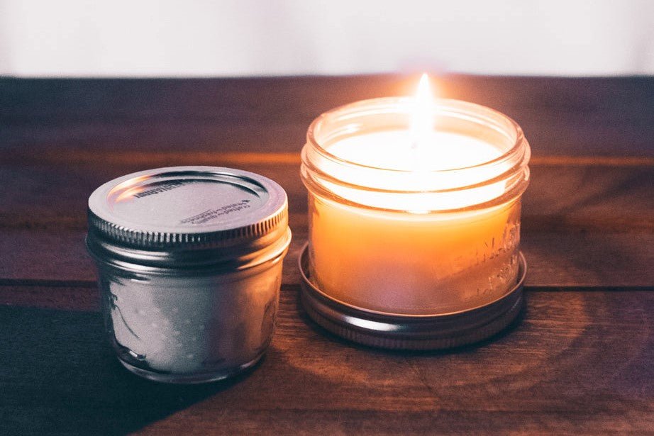 glass candle burning on wooden table.