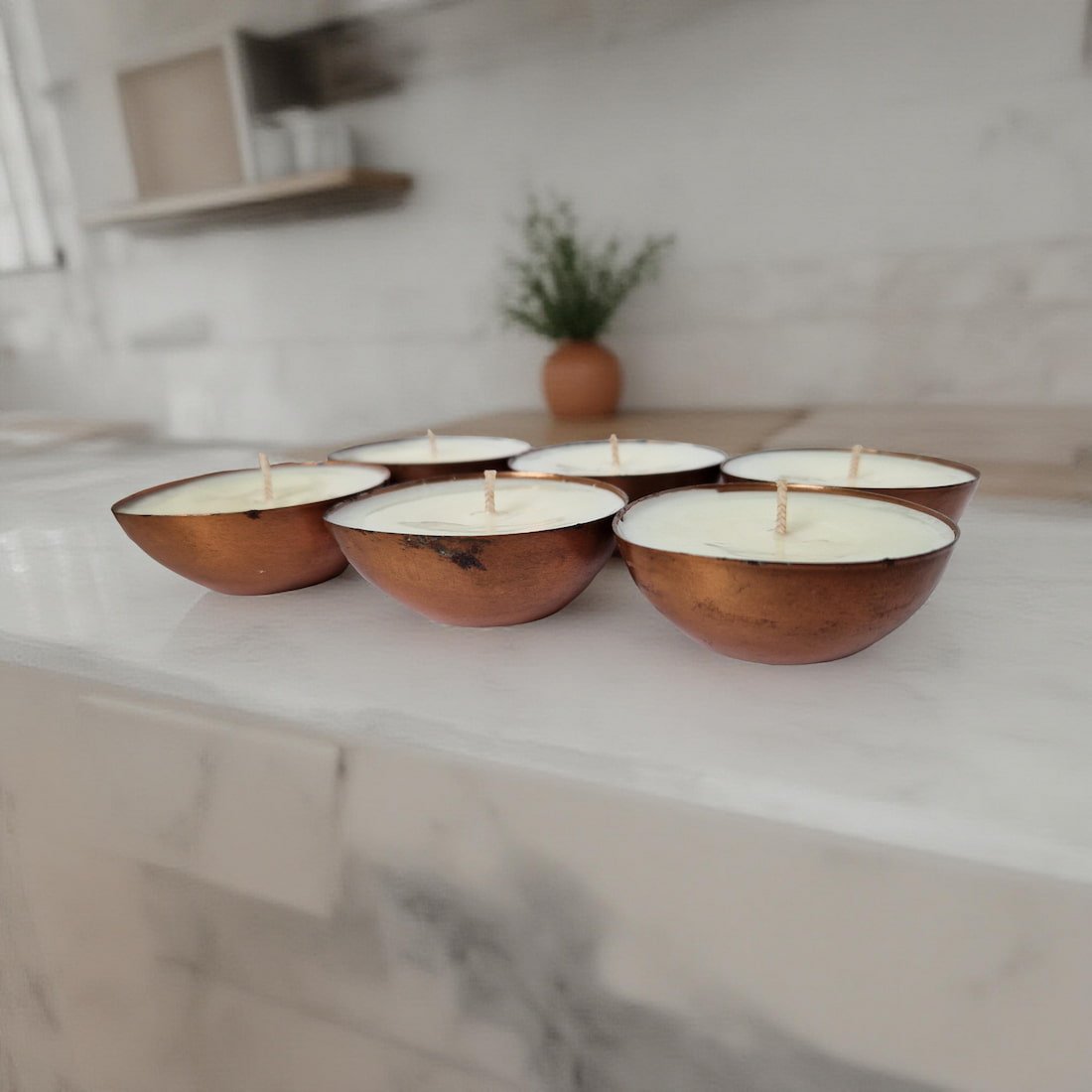 Wooden bowls with candles on a marble surface