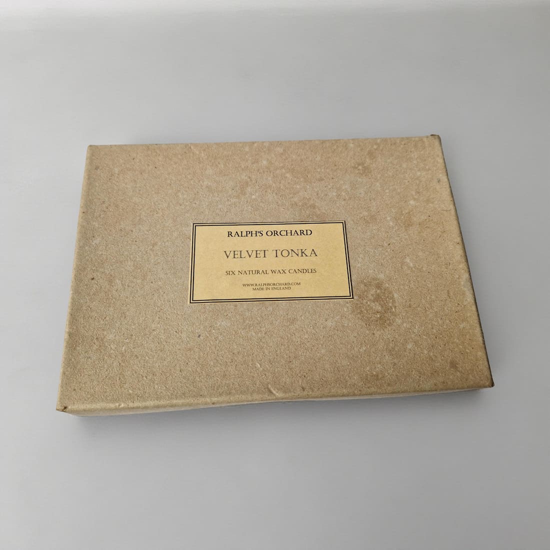 Brown cardboard box with 'Ralph's Orchard Velvet Tonka' label on a gray background