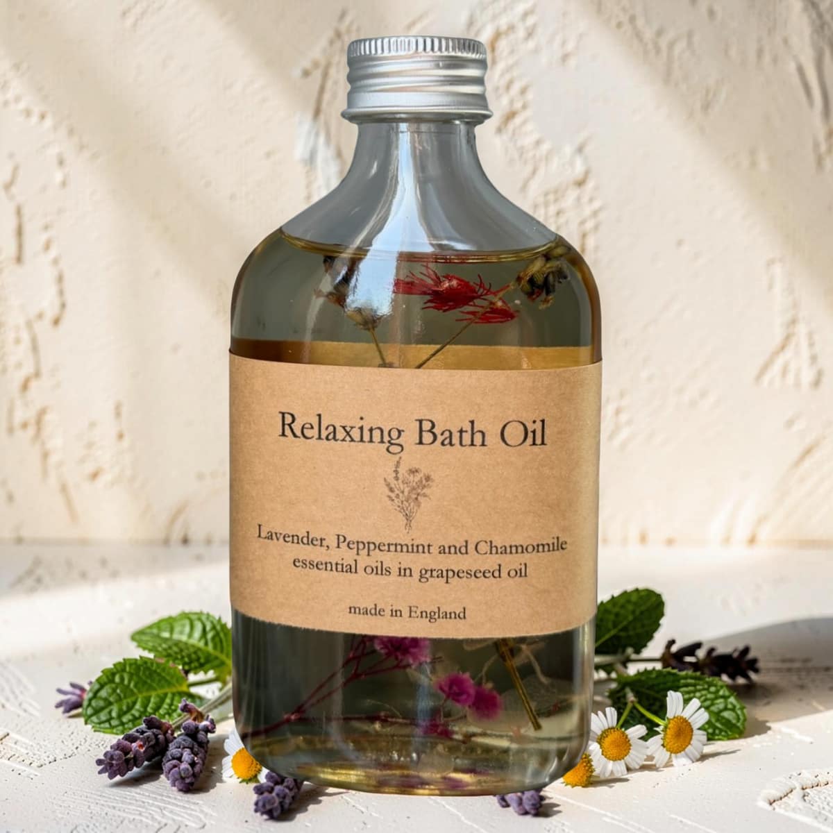 Bottle of relaxing bath oil with a label on a textured surface with flowers and leaves.