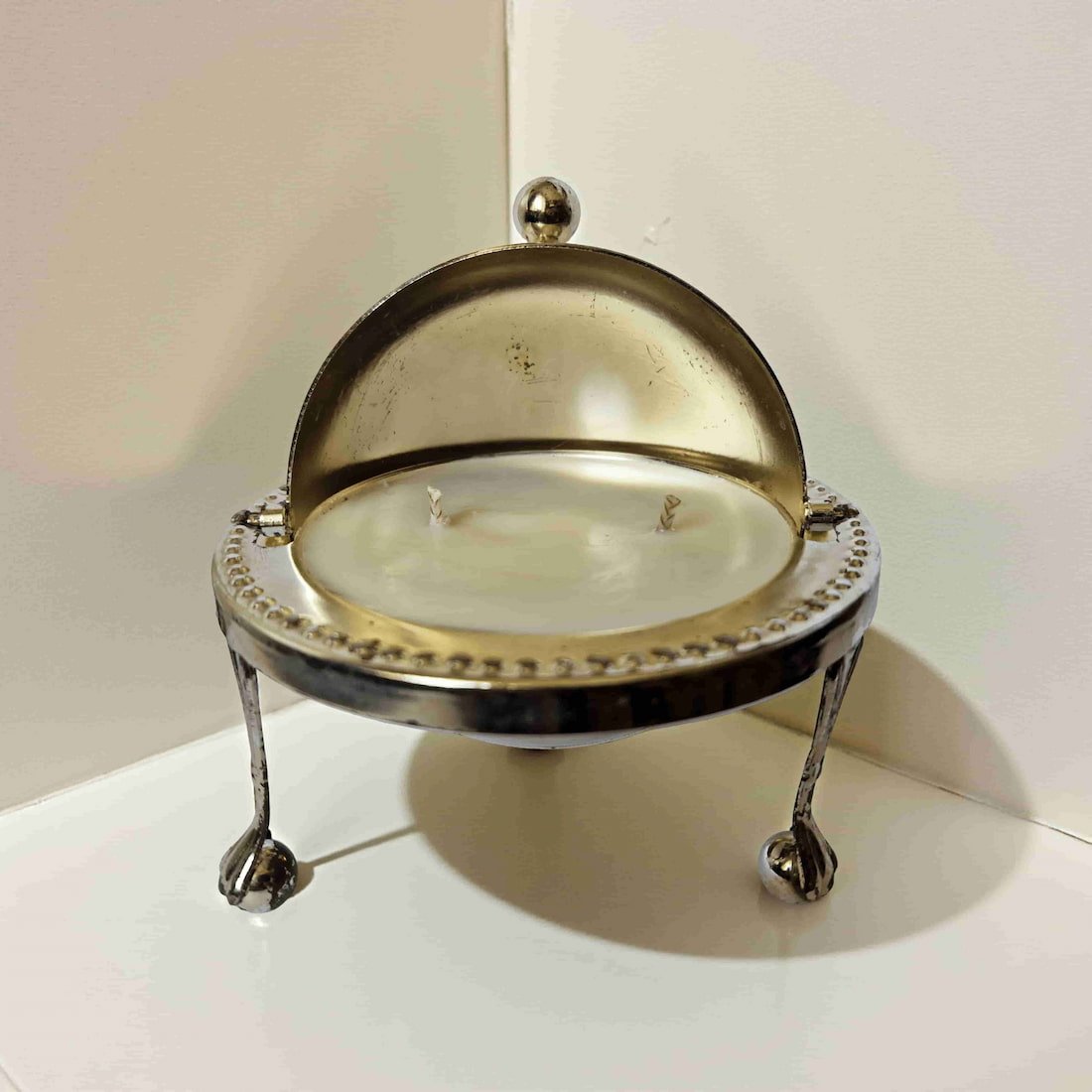 Decorative candle holder with a glass cover on a white surface