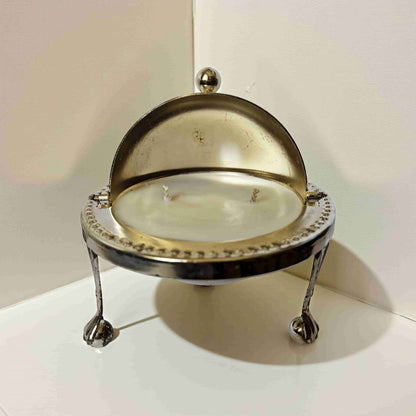 Decorative candle holder with a glass cover on a white surface