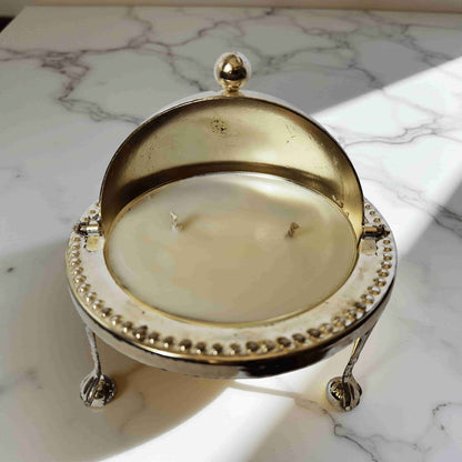 Decorative candle in a gold holder on a marble surface