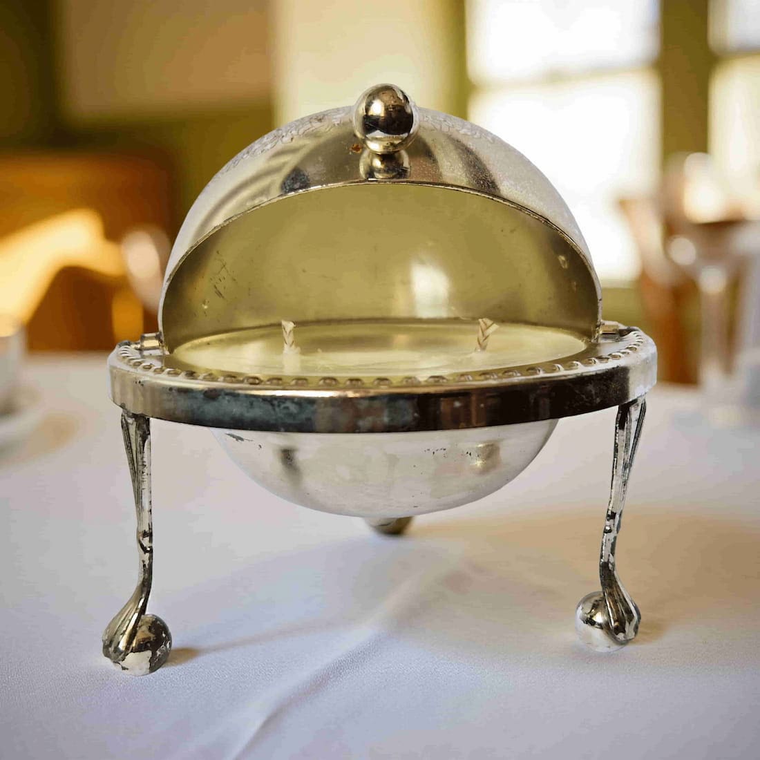 Silver chafing dish with a dome on a table