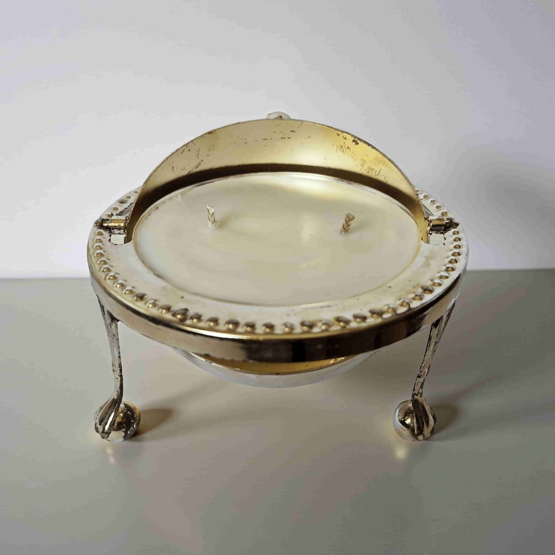 Decorative candle holder with a white candle on a plain background