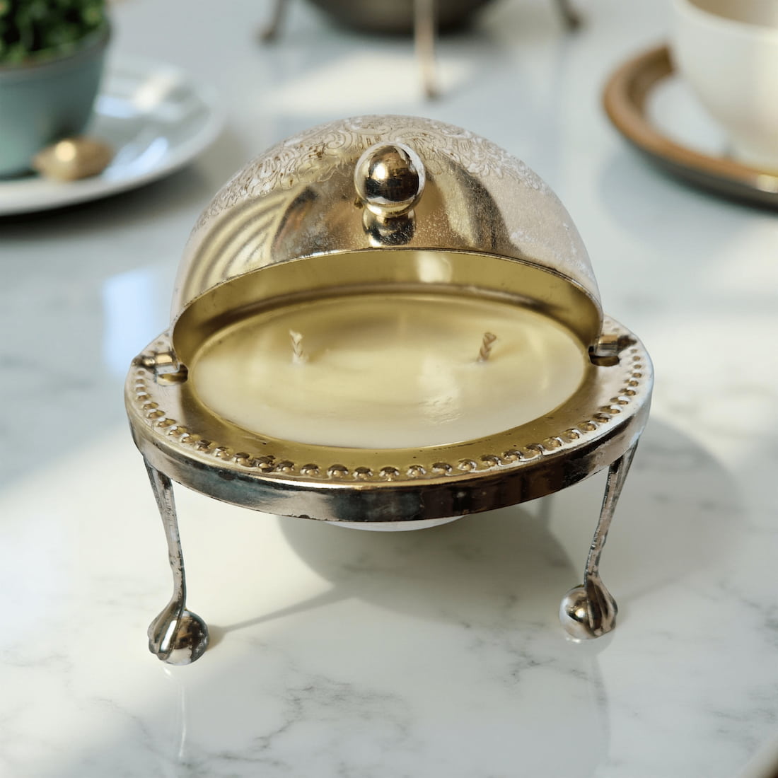 Decorative candle in a metallic holder on a marble surface