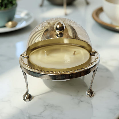 Decorative candle in a metallic holder on a marble surface