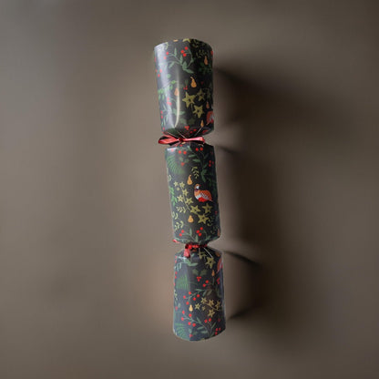 Two wrapped Christmas crackers with festive patterns on a dark background