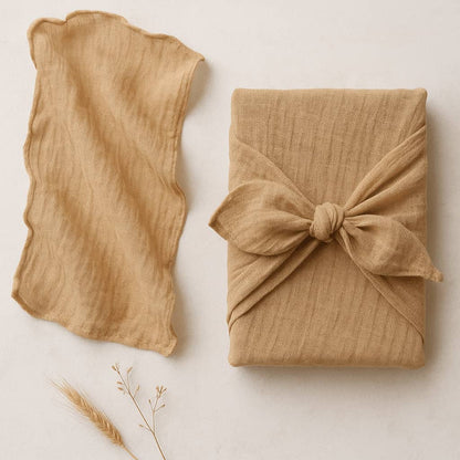 Two pieces of beige fabric, one draped over the other on a light background.