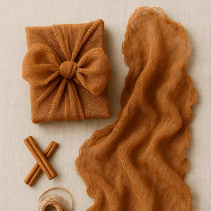 Brown fabric with a knot, cinnamon sticks, and twine on a beige background