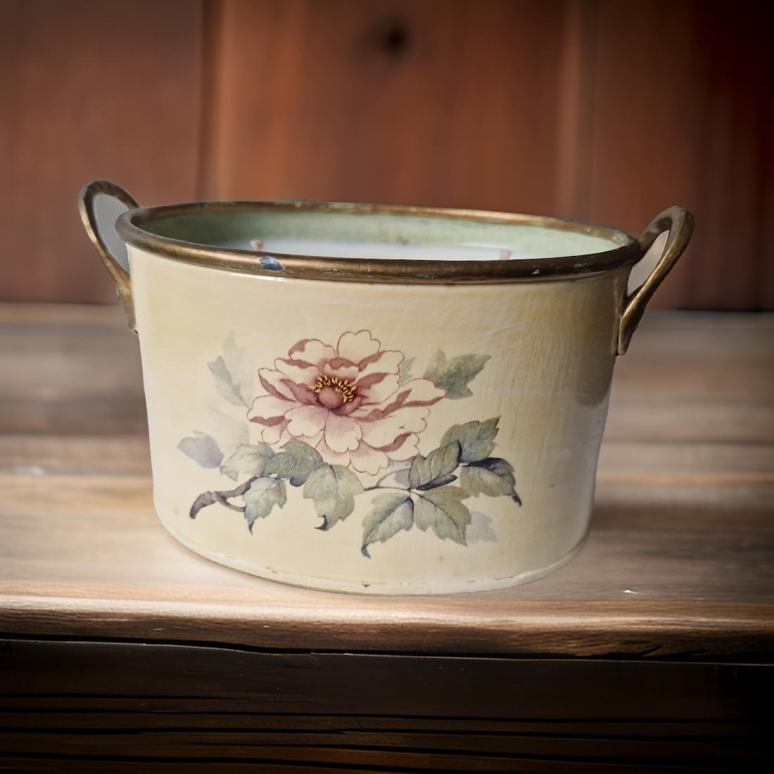 Vintage-style ceramic planter with floral design on a wooden surface