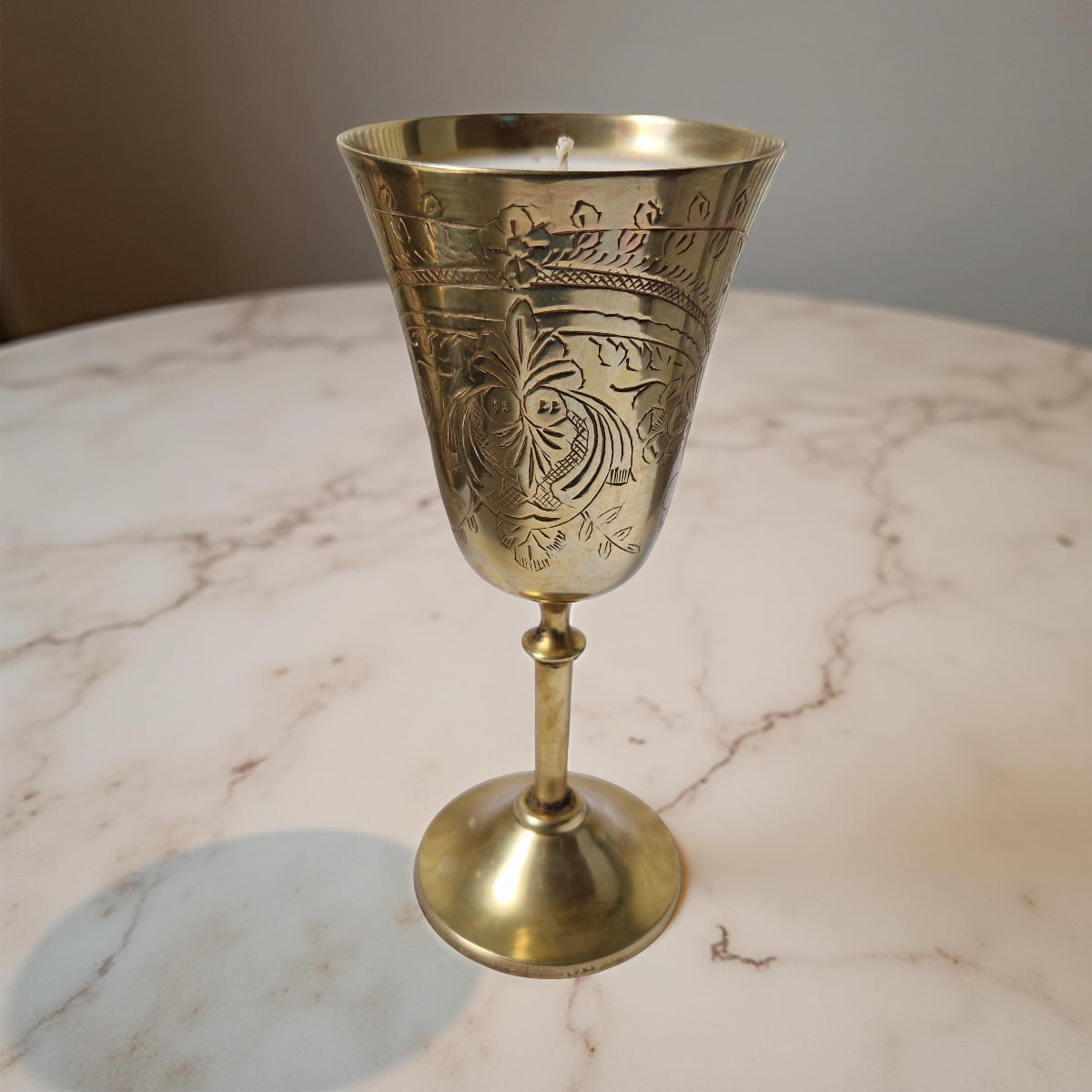 Decorative brass candle holder on a marble surface
