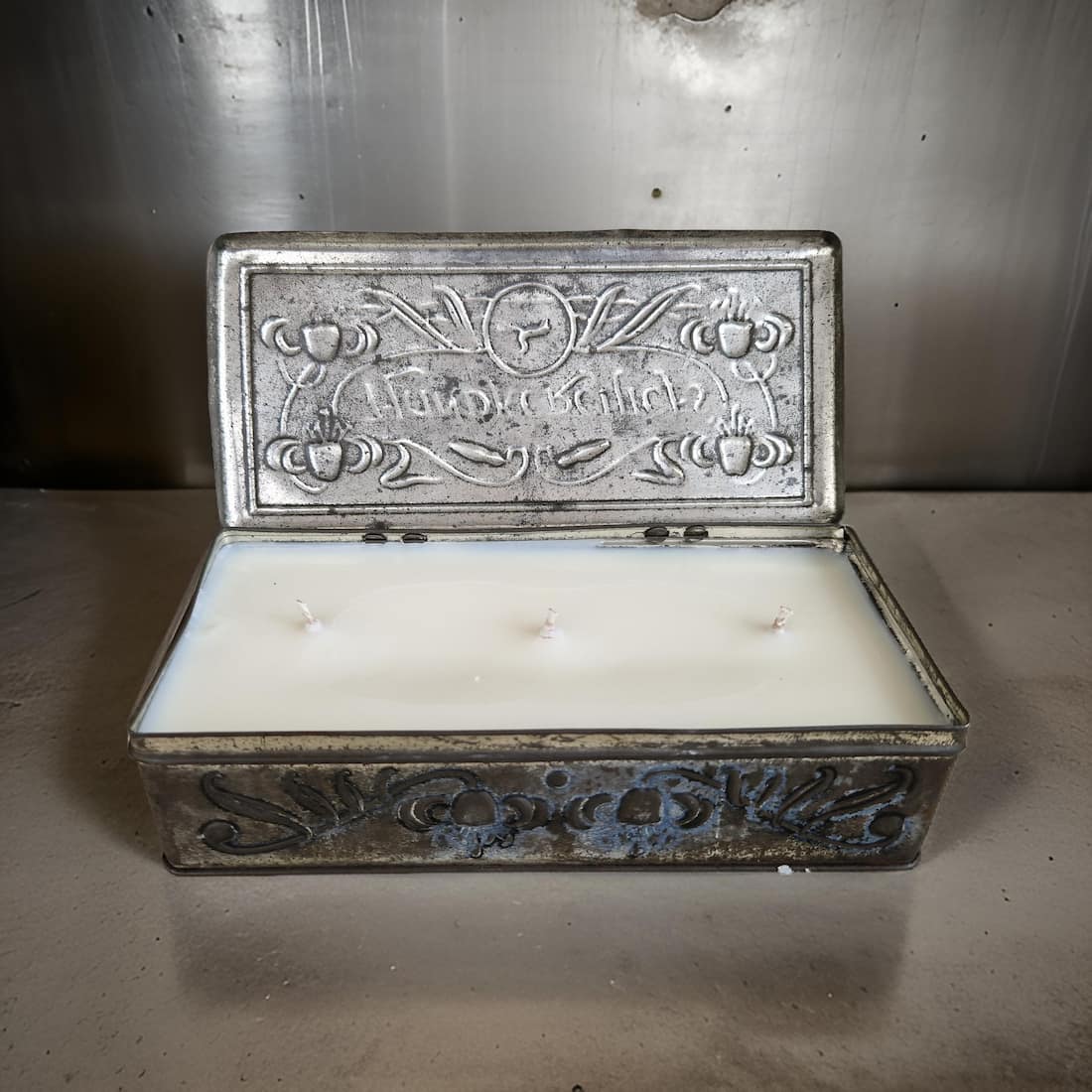 Decorative metal box with a candle inside on a metallic surface
