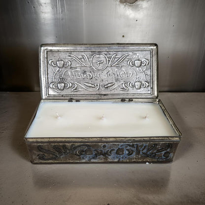 Decorative metal box with a candle inside on a metallic surface