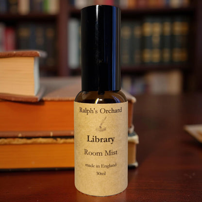 Bottle of Ralph's Orchard Library Room Mist on a wooden surface with books in the background