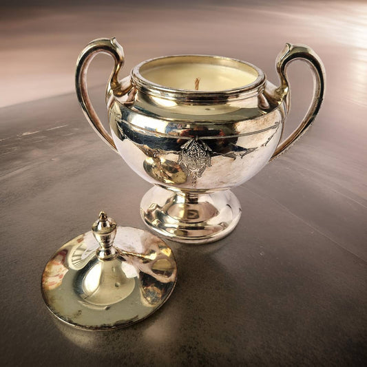 Silver trophy with candle on a reflective surface