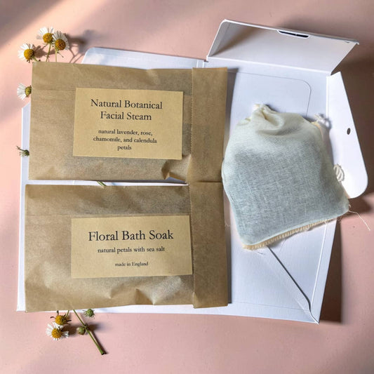 Two natural skincare products in brown paper packaging with labels on a pink background.