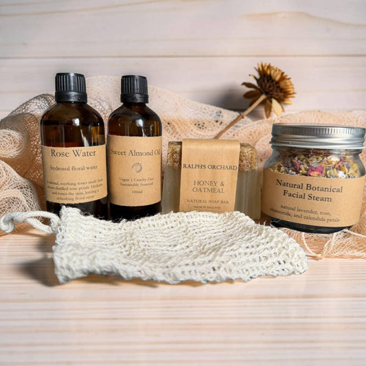 Set of natural skincare products including bottles, a jar, and soap on a wooden surface.