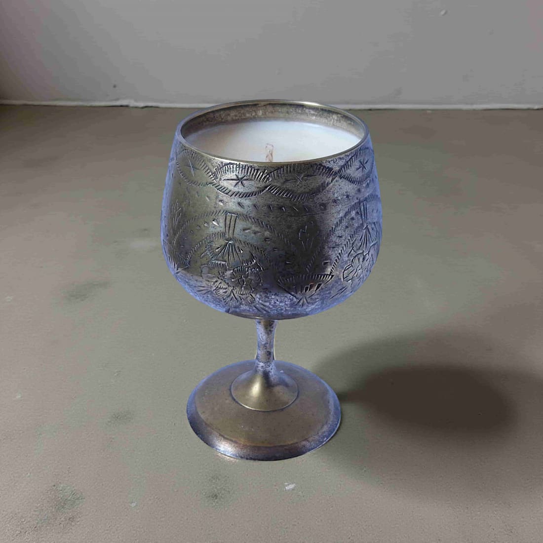 Decorative silver goblet on a gray surface