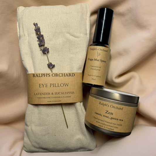 Ralph's Orchard eye pillow, yoga mat spray, and Zen candle on a soft beige background