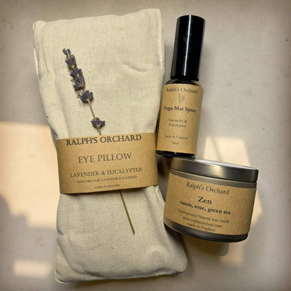 Eye pillow with lavender and eucalyptus, yoga mat spray, and candle labeled 'Ralph's Orchard' on a neutral background.