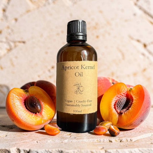 Bottle of apricot kernel oil with apricots on a wooden surface