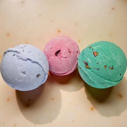 Three colorful bath bombs on a light surface