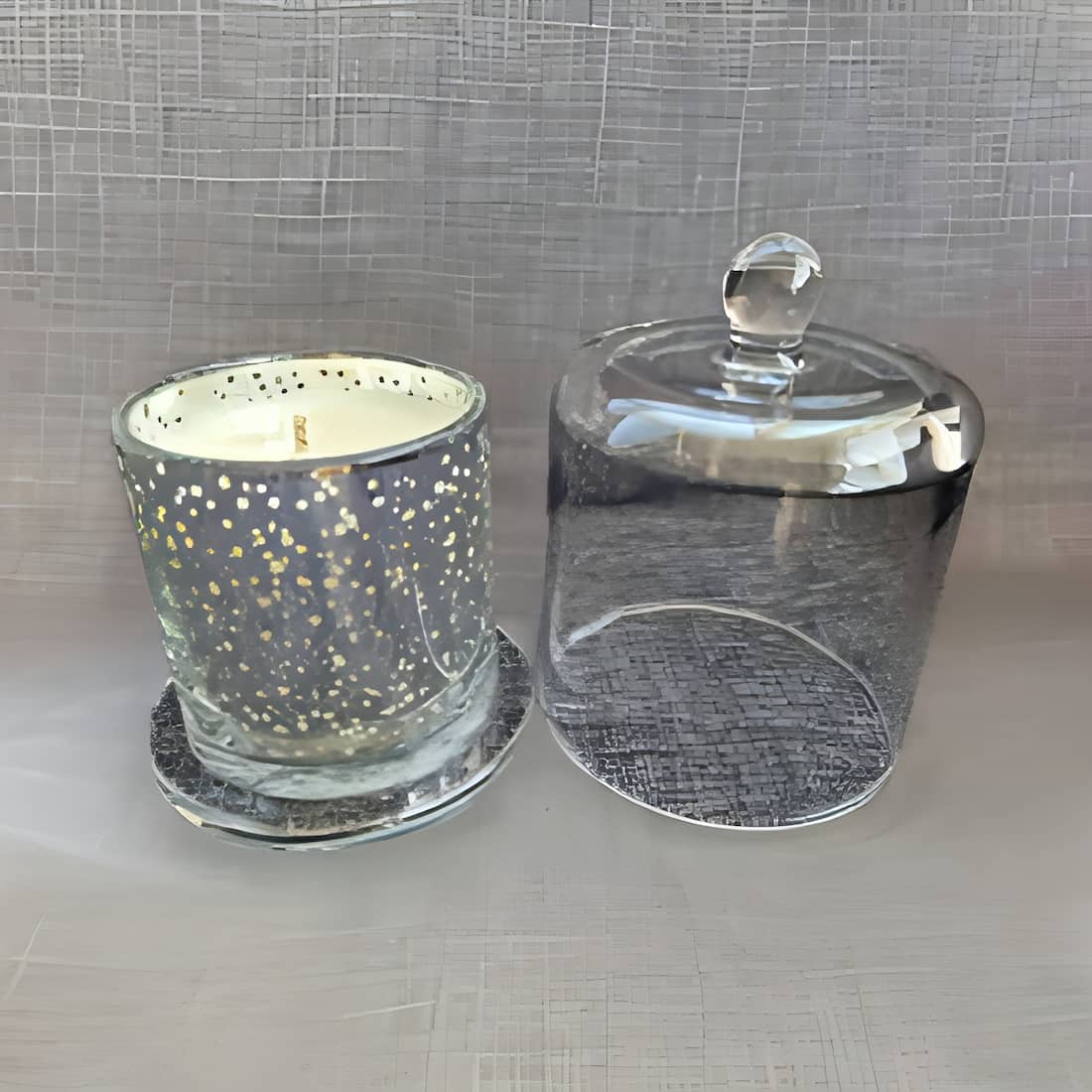 Glass candle holder with a lid on a textured surface