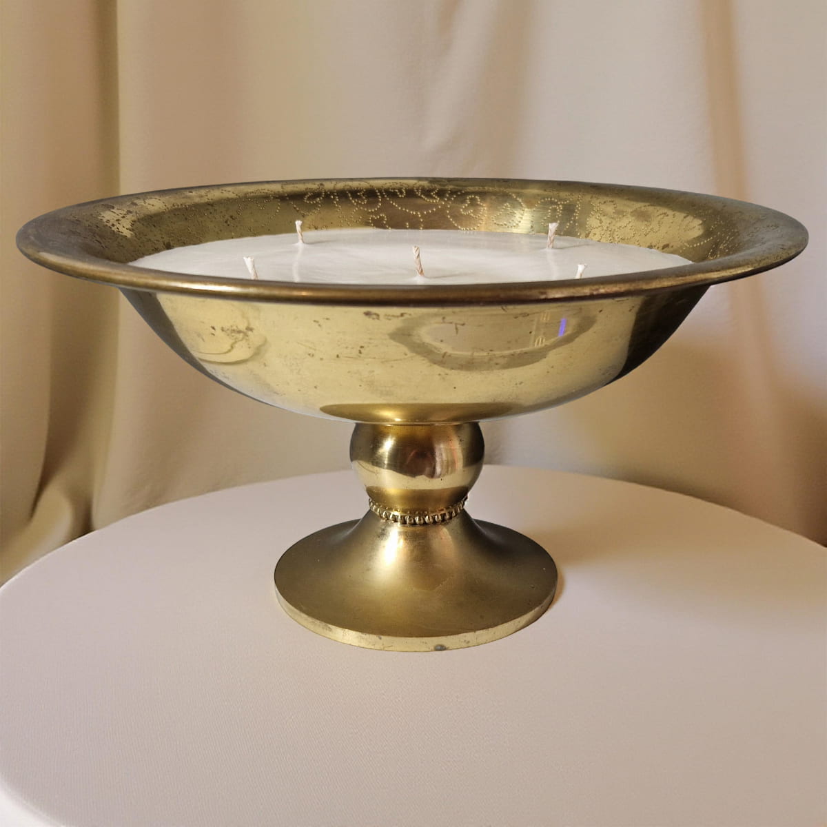Gold candle holder with candles on a white surface