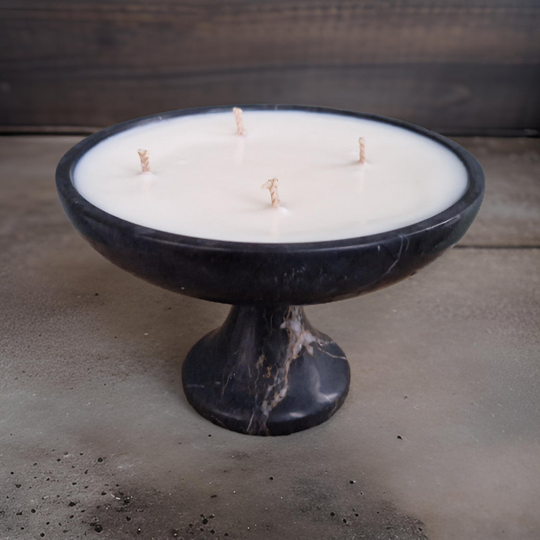 Candle in a black marble holder on a concrete surface