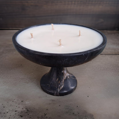 Candle in a black marble holder on a concrete surface