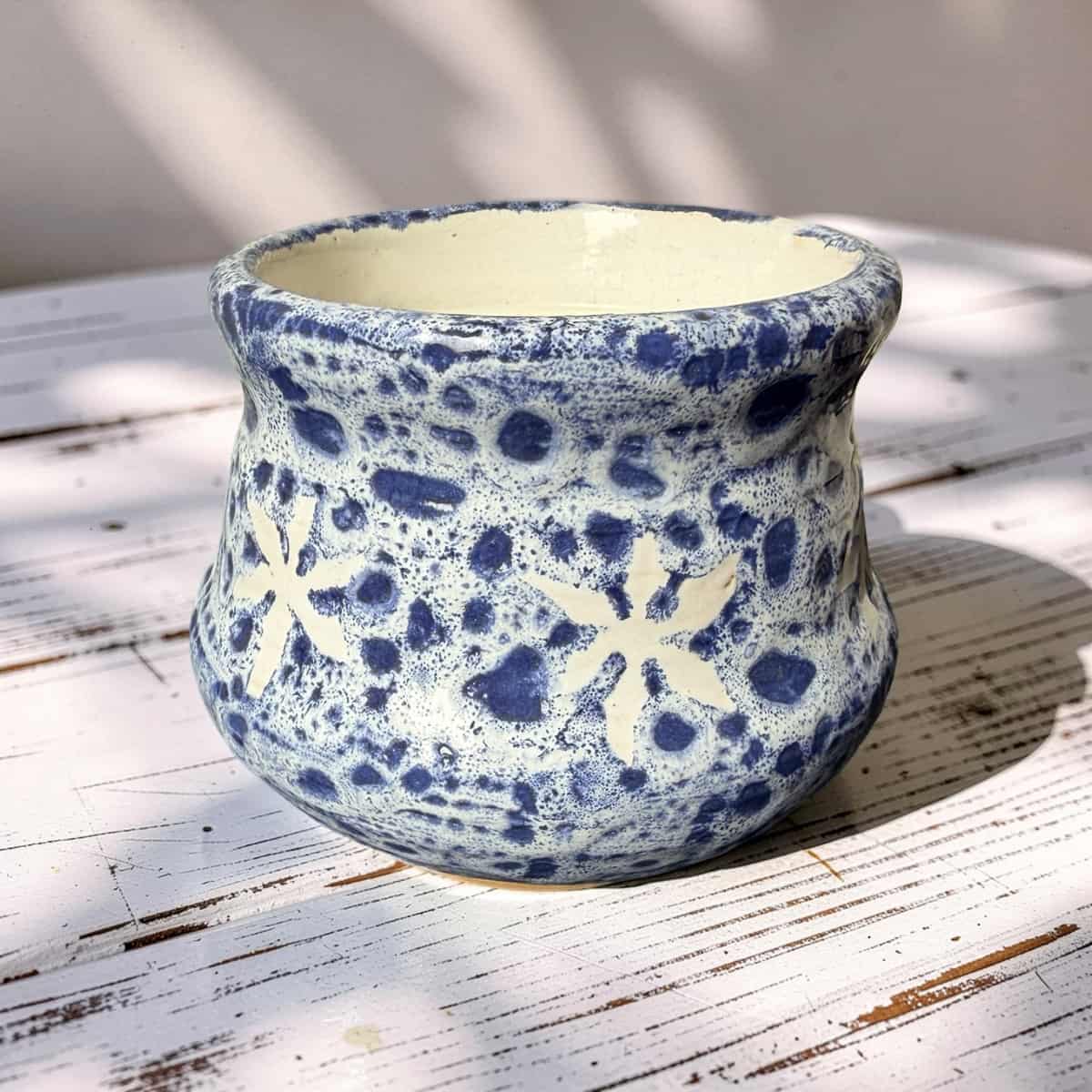 Ceramic pot with blue and white floral patterns on a wooden surface