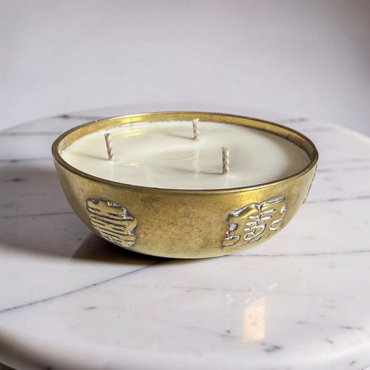 Decorative candle in a gold holder on a marble surface