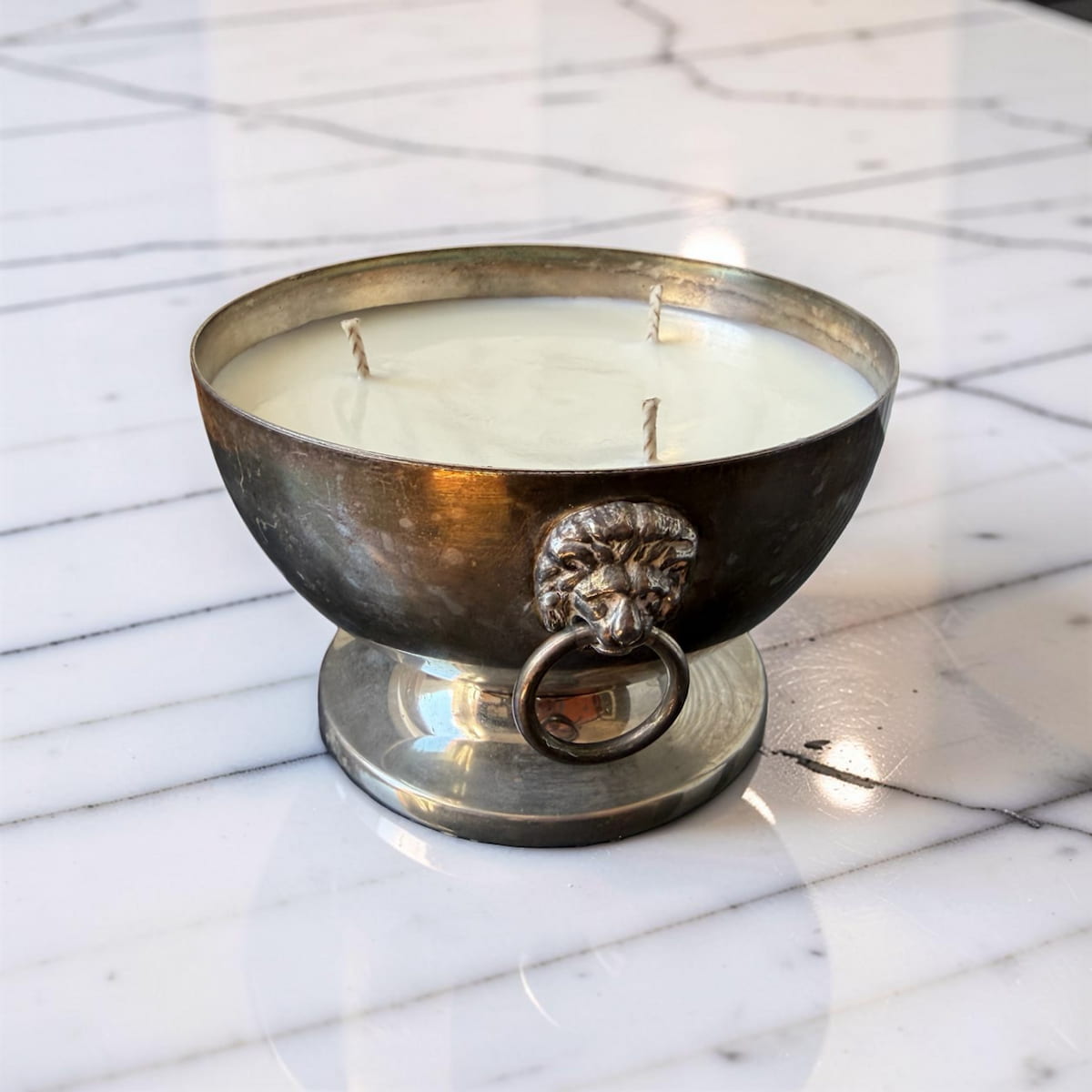 Decorative candle in a metal holder on a marble surface
