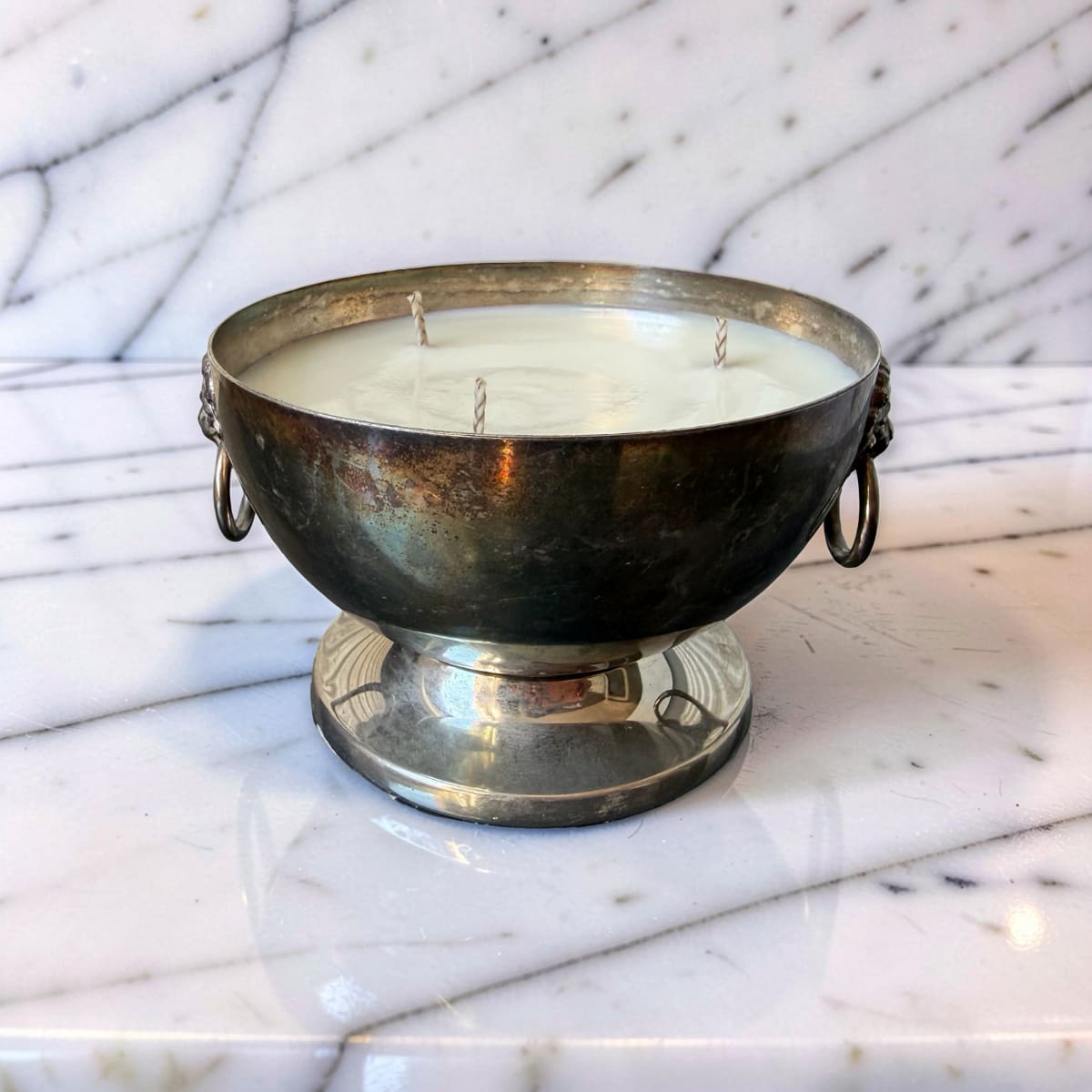 Decorative candle in a metallic holder on a marble surface