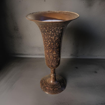 Decorative bronze vase with intricate patterns on a plain background