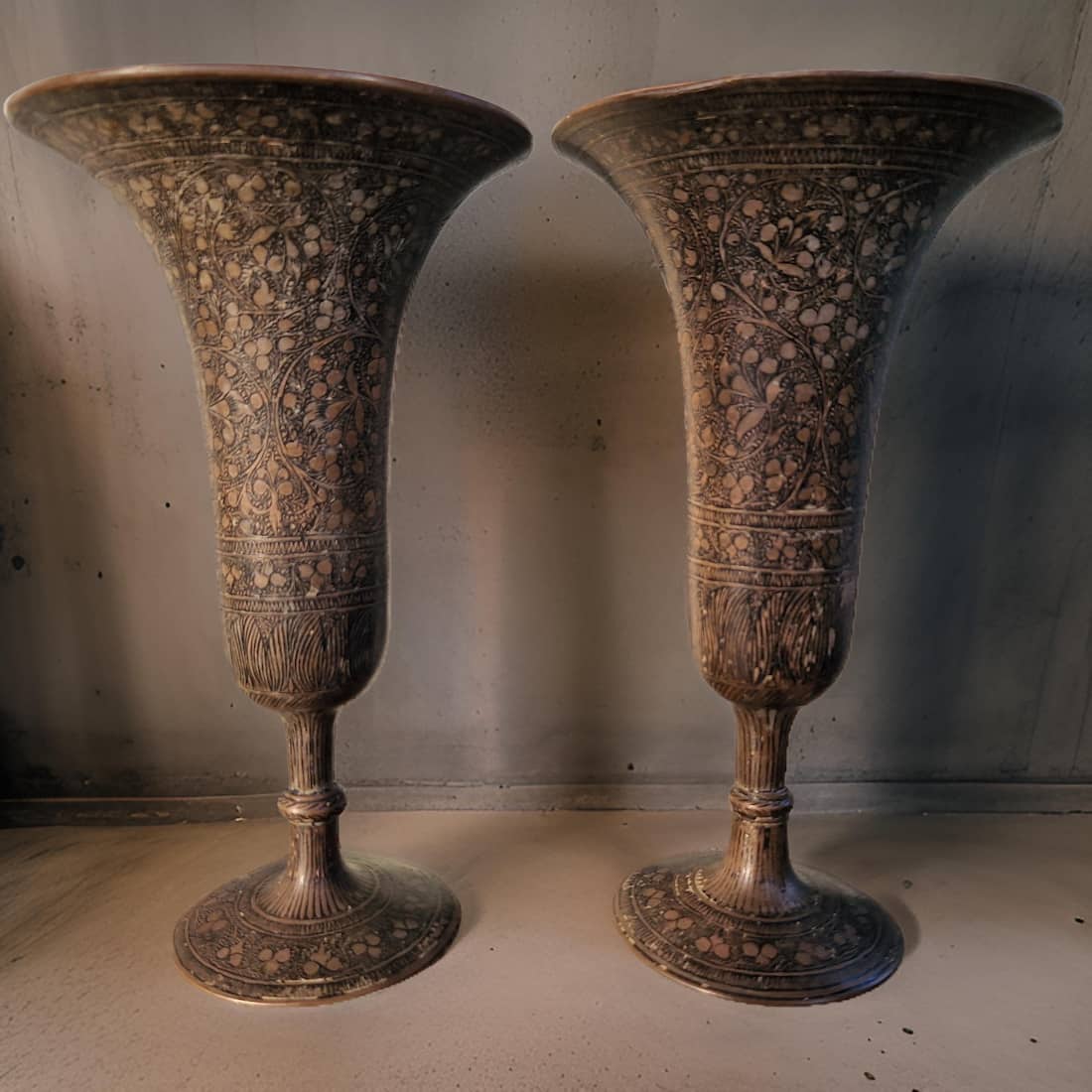 Two ornate vases with intricate patterns on a plain background