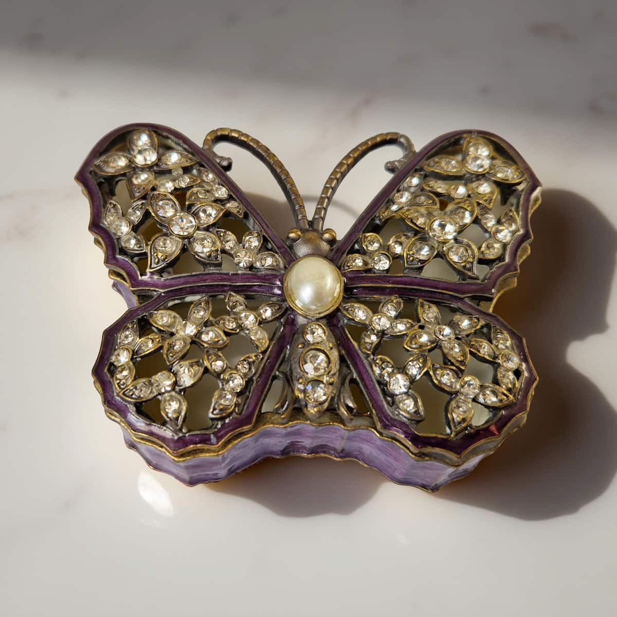 Butterfly-shaped jewelry box with rhinestones on a light background