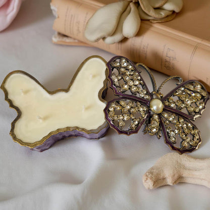 Butterfly-shaped object with decorative embellishments on a soft surface