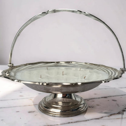 Silver metal basket with a handle on a marble surface