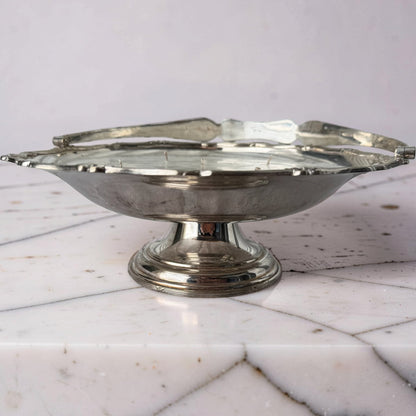 Silver decorative bowl on a marble surface with a white background